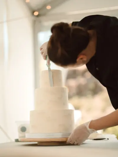 Natalie Zatoka NCake assembling the three-tier cake at the wedding venue